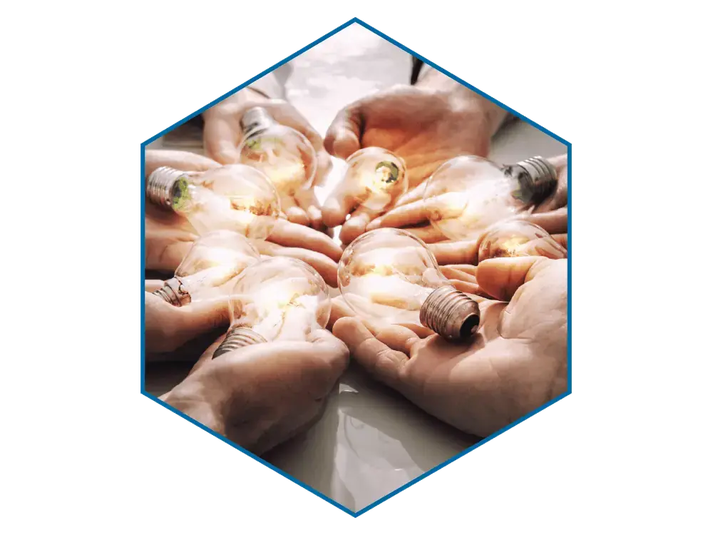 A circle of hands of several people holding out lit lightbulbs